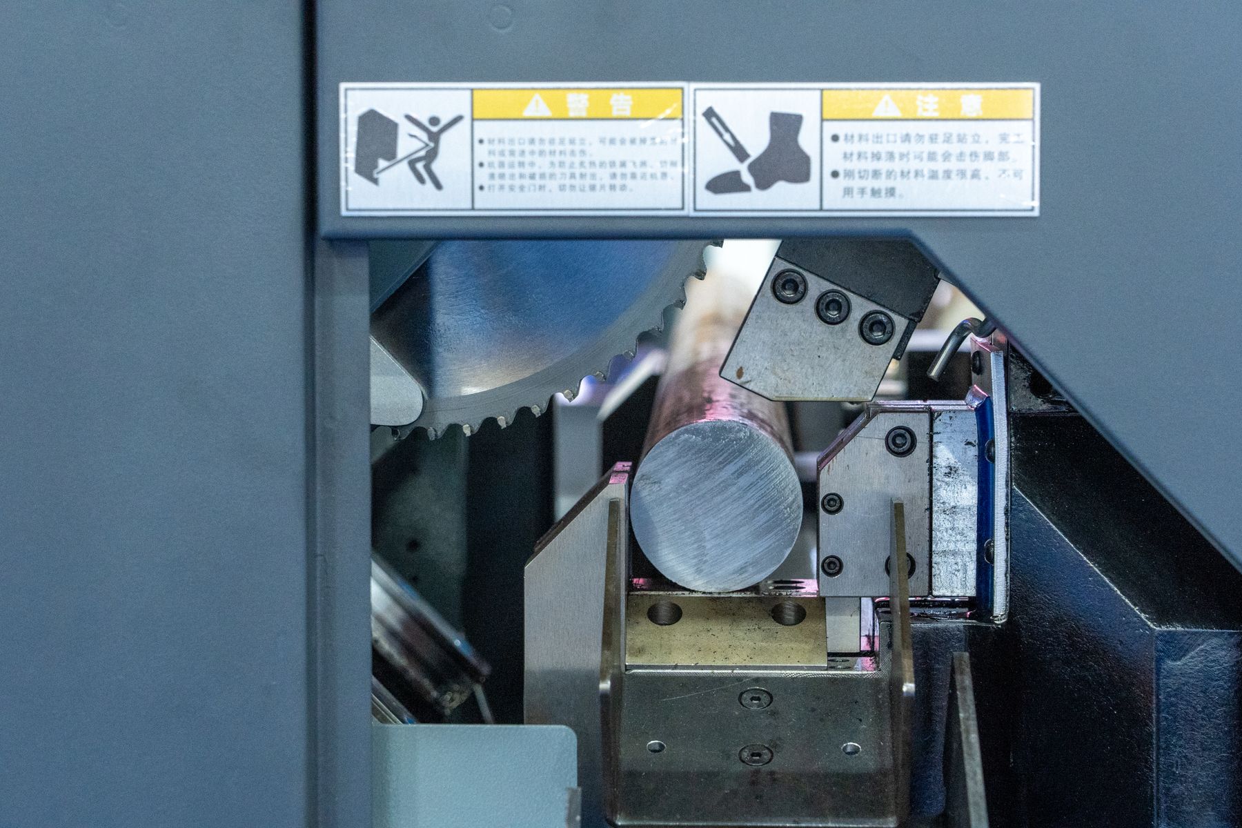 Industrial saw cutting a steel bar